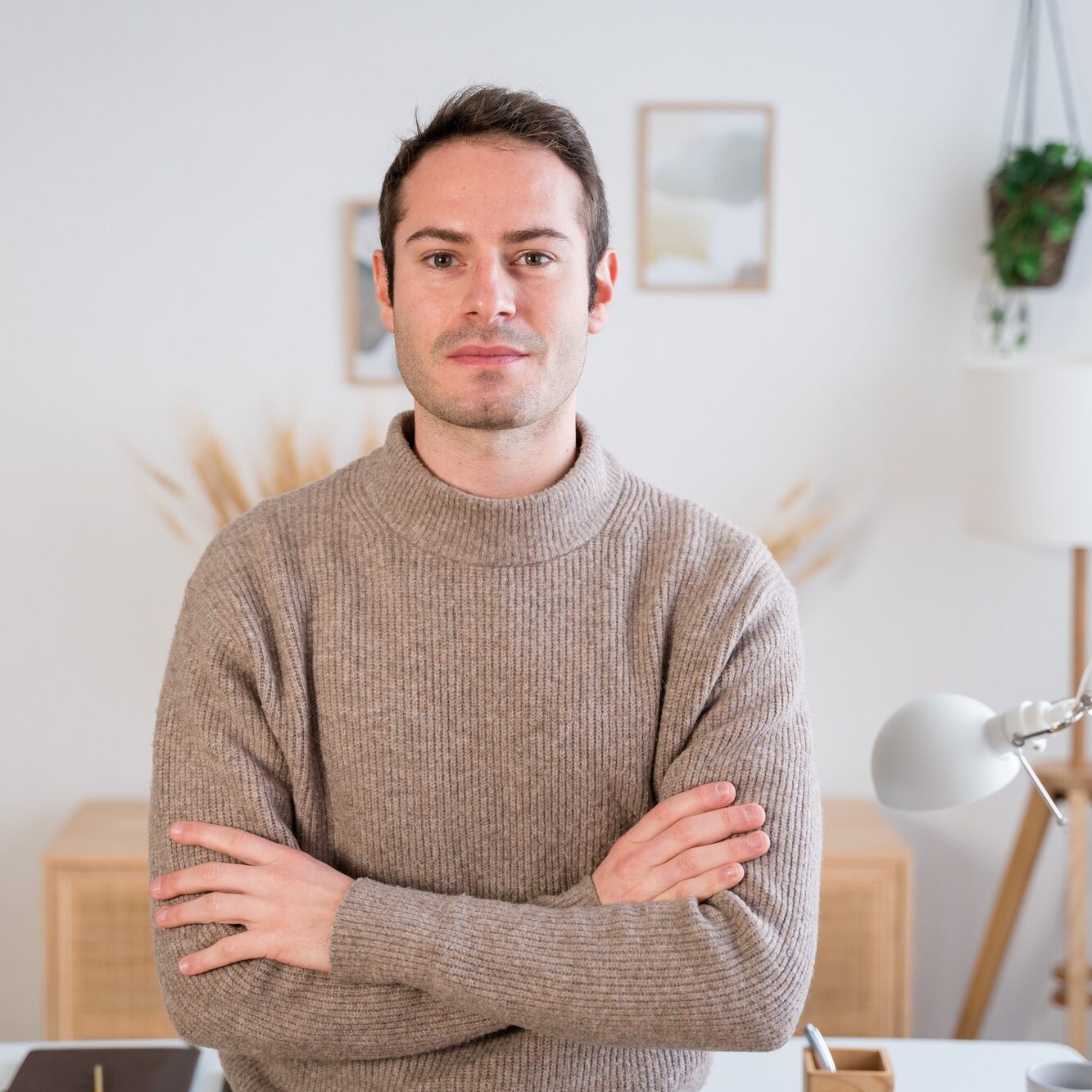 Young man with folded arms looking at camera